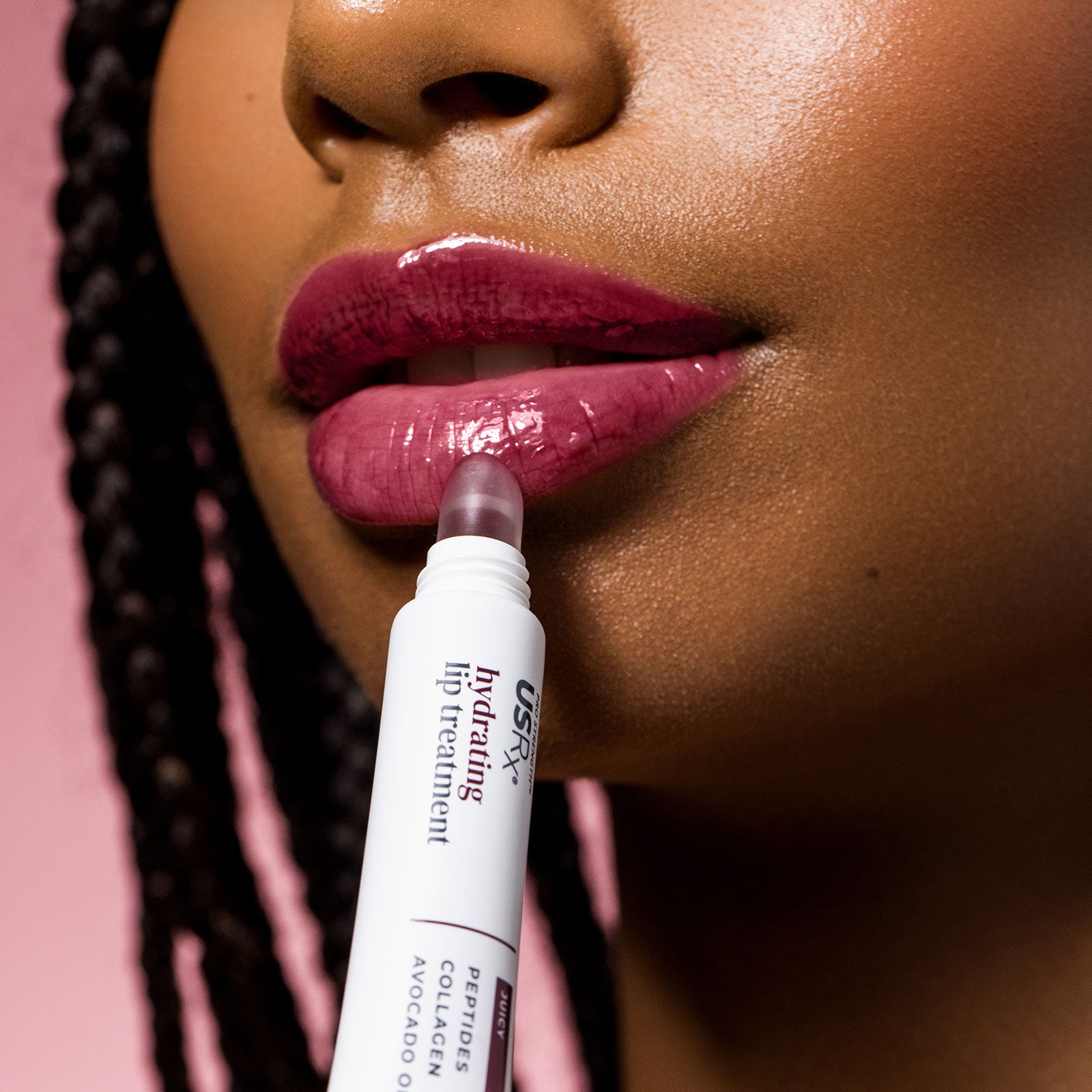 Woman applying USRx Tinted Hydrating Lip Treatment in Juicy to her lips