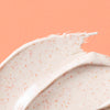 Close-up of Urban Skin Rx Purifying Pumpkin Mask textured cream on a peach background.