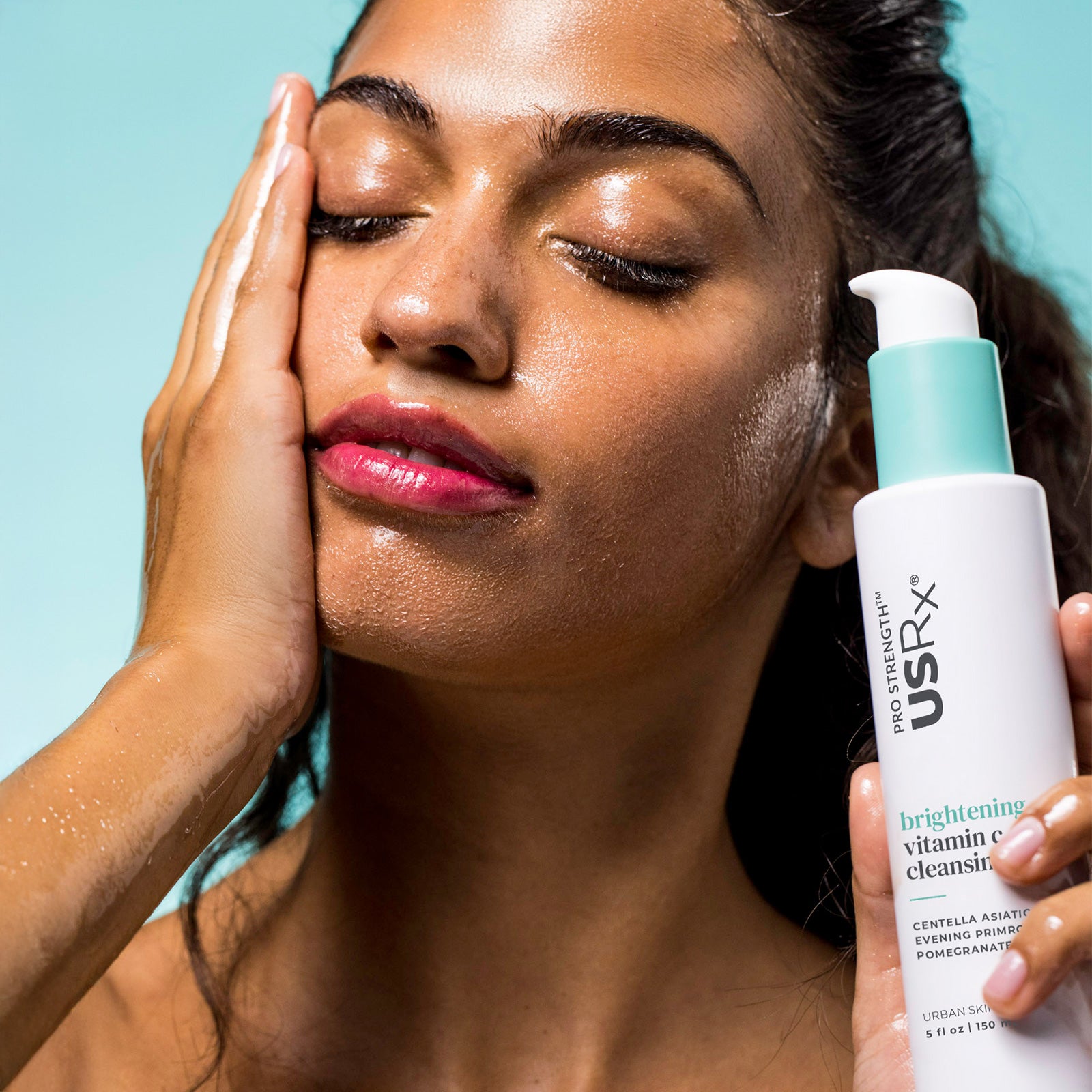 Woman applying USRx Vitamin C Cleansing Oil to her face