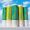5 sticks of USRX Sunscreen Lip Balm SPF 30 set against a light blue sky background