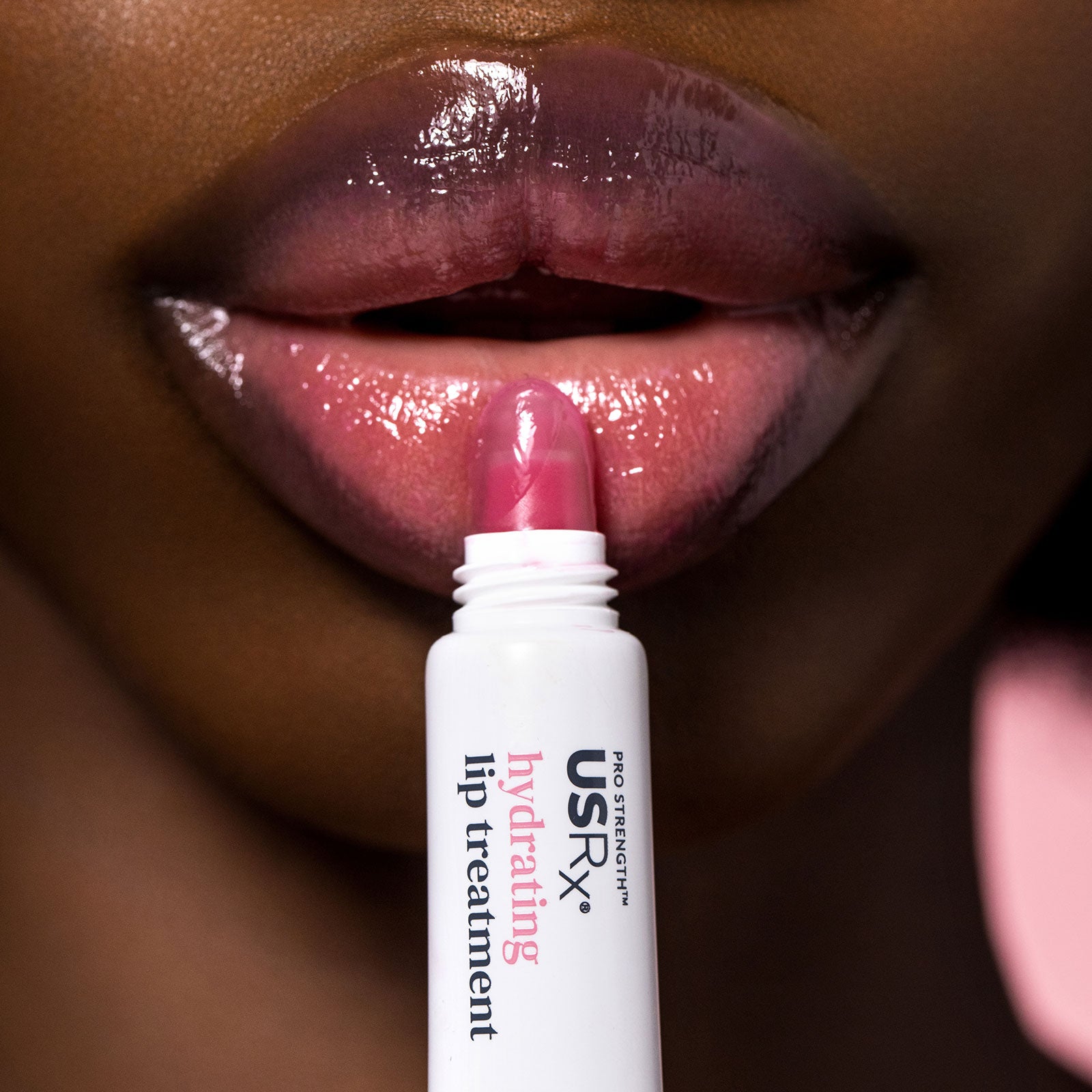 Woman applying USRx Tinted Hydrating Lip Treatment in Jelly to her lips