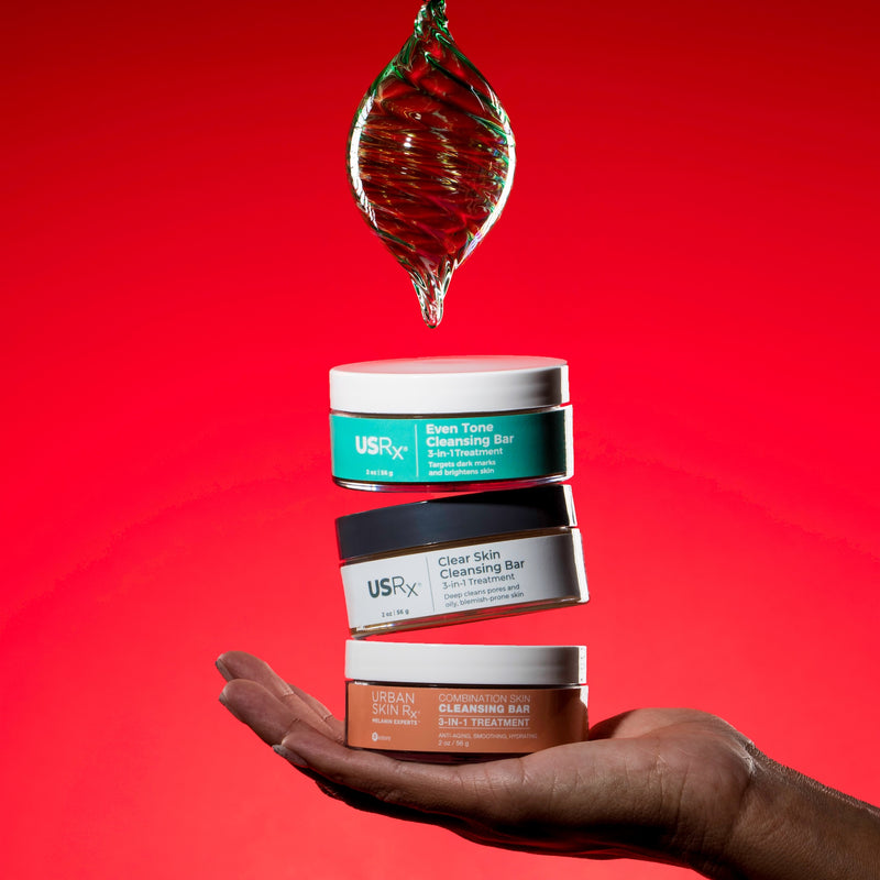 Woman holding 3 USRx cleansing bars on a red background