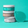 USRx cleansing bars with a green scrubber on a teal background