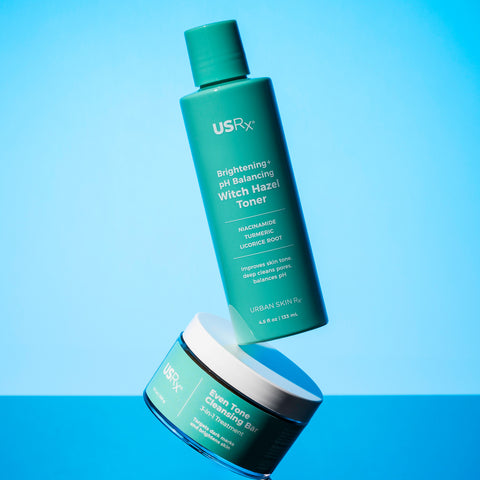 Bottles of USRx witch hazel toner and even tone cleansing bar on a blue background