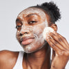 Woman applying USRx even tone cleansing bar to her face