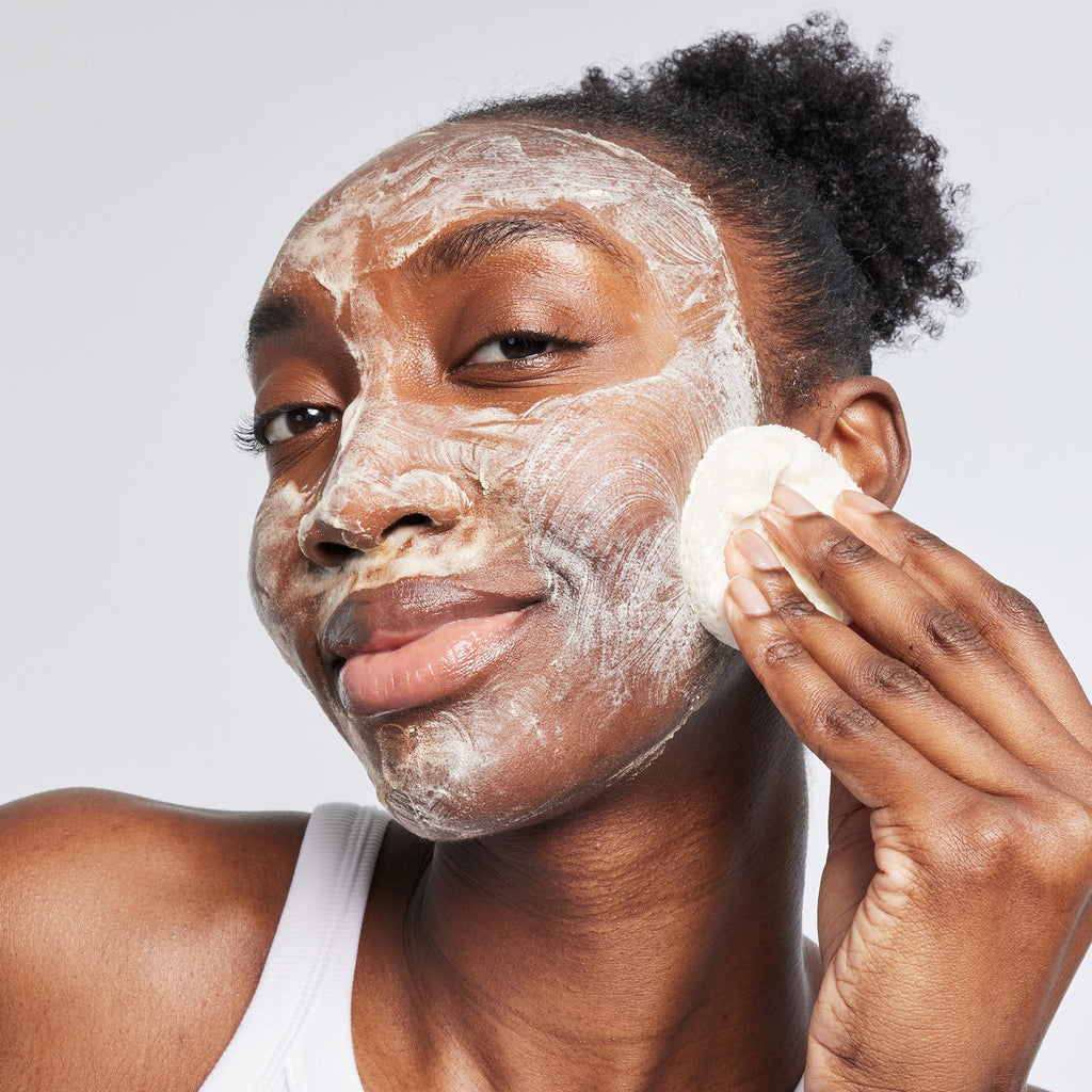 Woman applying USRx even tone cleansing bar to her face