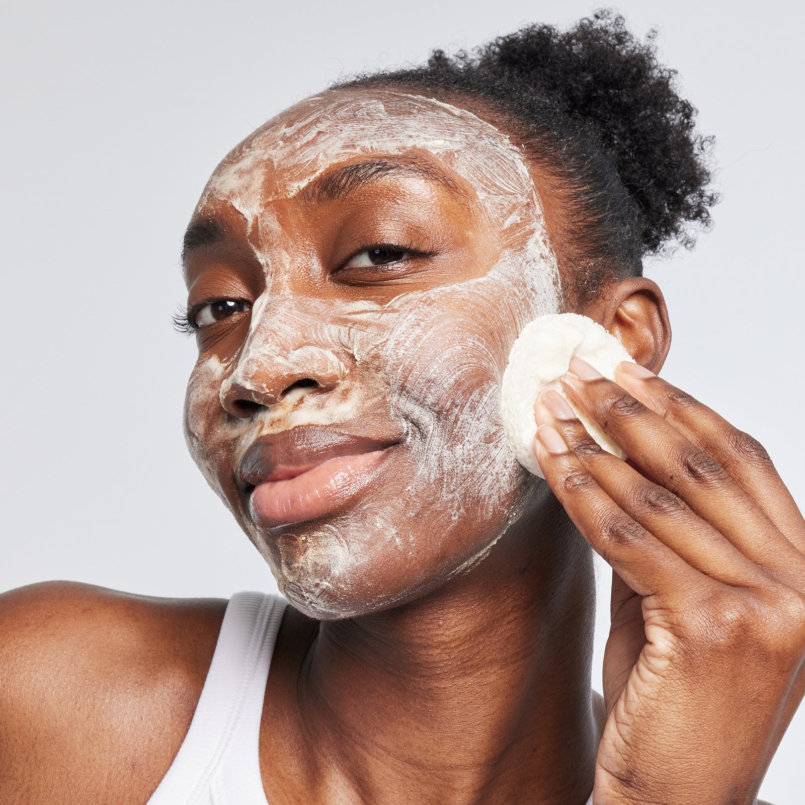 Woman applying USRx even tone cleansing bar to her face