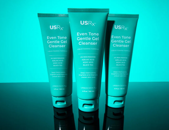 Three bottles of USRx Even Tone Gentle Gel Cleanser on a light blue background