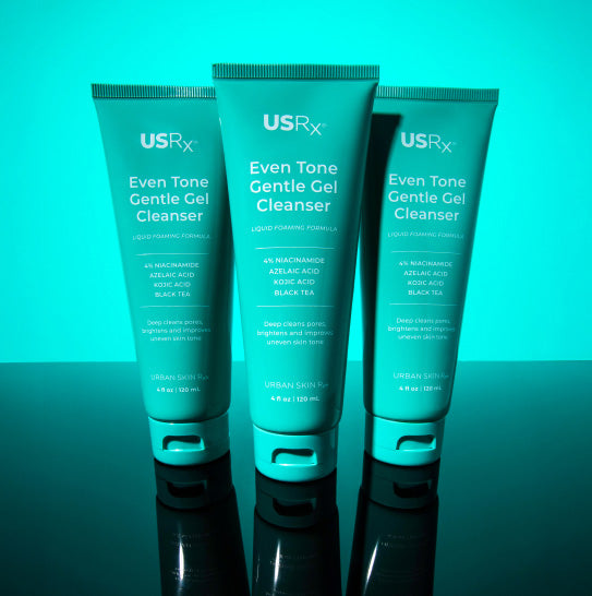 Three bottles of USRx Even Tone Gentle Gel Cleanser on a light blue background