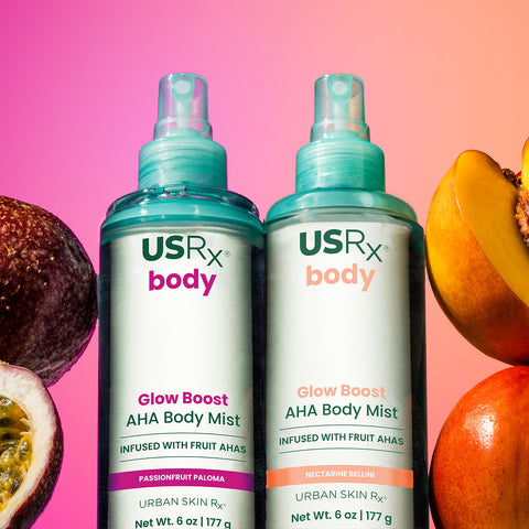 Bottles of USRx Glow Boost AHA Body Mists in Passionfruit Paloma and Nectarine Bellini surrounded by fresh fruit