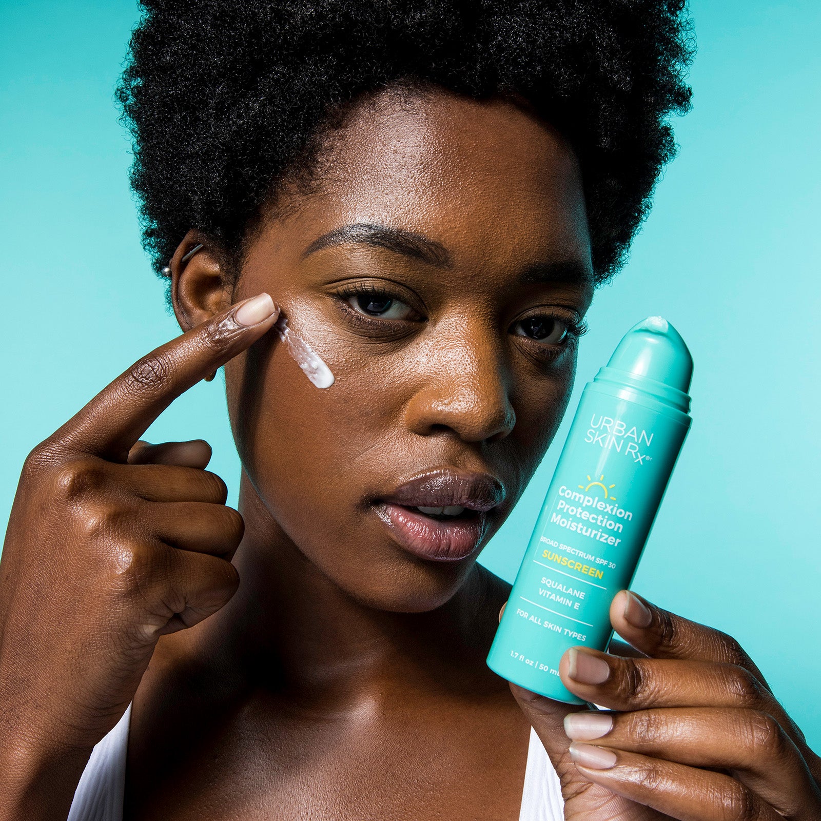 Woman applying USRx Complexion Protection Moisturizer to her face