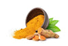 Ground turmeric pouring out of a brown bowl next to a turmeric root on a white background