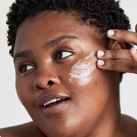 Woman applying USRX HydraBalance Brightening Moisture Infusion on her face